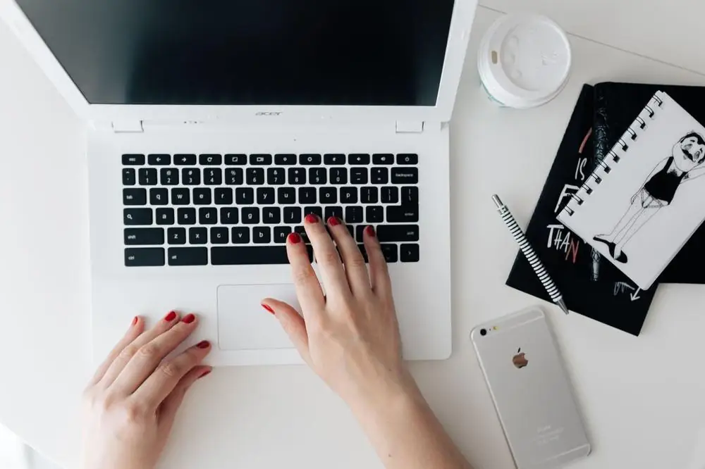 Hands typing on a laptop